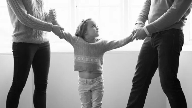 bērns starp diviem cilvēkiem