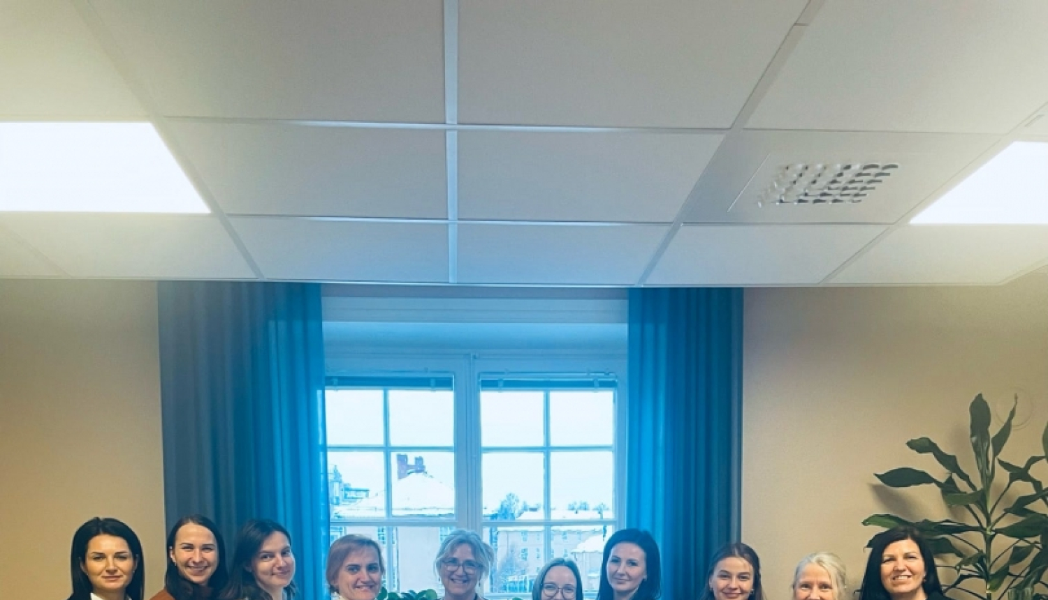 Kolektīvs telpā pie loga