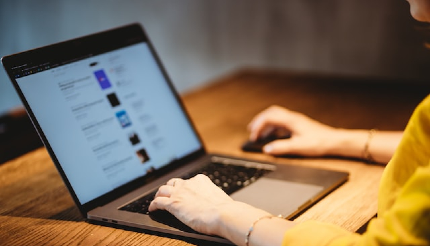 Laptops uz galda, redzmas cilvēka rokas