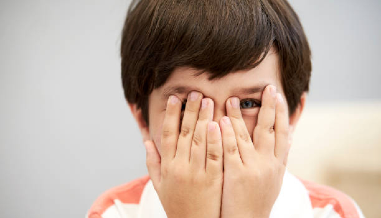 zēns ar rokām aizsedzis acis