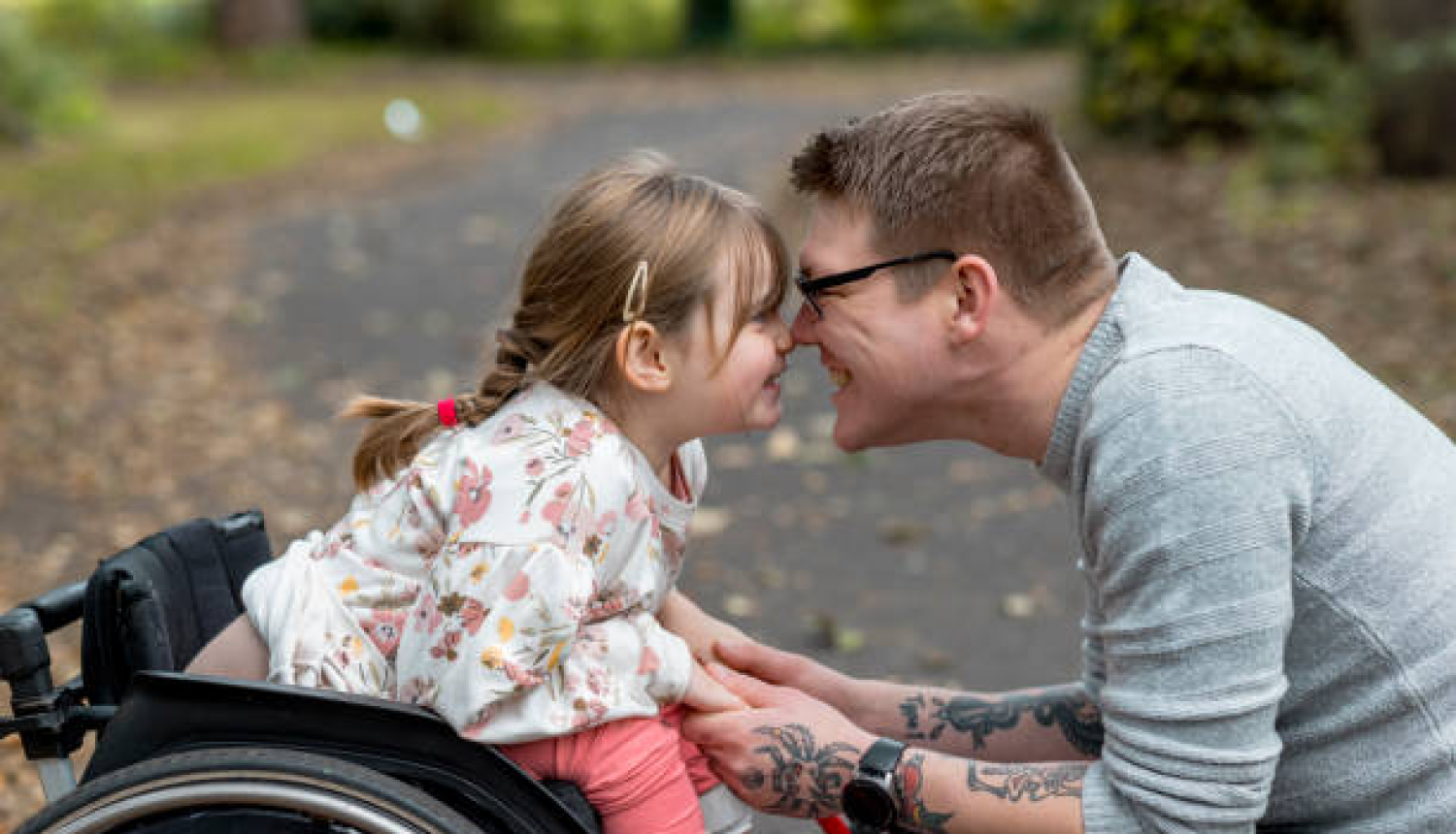 Vecāks ar bērnu ratiņkrēslā
